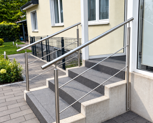 Sicherer Treppenaufgang für ein Kind – eine Lösung, die mitwächst Bei diesem Projekt stand ein ganz besonderer Kunde im Mittelpunkt: ein Kind, dem es schwerfiel, die Treppen am Hauseingang selbstständig hinaufzugehen. Die vorhandene Treppe bot dafür zu wenig Unterstützung. Deshalb sollte eine Lösung entstehen, die dem Kind mehr Halt gibt – und gleichzeitig auch für die Eltern für mehr Sicherheit sorgt. Ein Handlauf auf der richtigen Höhe Neben dem normalen Handlauf haben wir die Füllstäbe des Geländers bewusst in die Planung einbezogen. Sie erfüllen nicht nur die Funktion einer Geländerfüllung: Einer der Stäbe kann vom Kind während der Wachstumsphase wie ein kleiner, tiefer liegender Handlauf genutzt werden. So hat das Kind bereits jetzt eine gut erreichbare Möglichkeit, sich beim Treppensteigen festzuhalten. Mit zunehmender Körpergröße kann später der eigentliche Handlauf genutzt werden. Das Ergebnis ist damit keine Lösung nur für den heutigen Tag, sondern eine Konstruktion, die das Kind über mehrere Entwicklungsphasen begleiten kann. Mehr Selbstständigkeit – und ein besseres Gefühl für die Eltern Gerade bei Kindern bedeutet Sicherheit nicht zwangsläufig, ihnen jeden Schritt abzunehmen. Eine passende Unterstützung kann dabei helfen, alltägliche Wege möglichst selbstständig zu bewältigen. Und auch für die Eltern hat sich etwas verändert: Der Treppenbereich ist nun deutlich besser abgesichert und bietet verschiedene Möglichkeiten zum Festhalten. Ein schönes Beispiel dafür, dass ein individuell geplanter Handlauf weit mehr sein kann als nur ein Stück Edelstahl.