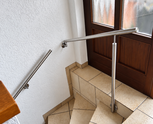Edelstahl-Handläufe an einer viertelgewendelten Treppe in Burbach mit seitlich an der Treppe befestigtem Stützpfosten