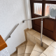 Edelstahl-Handläufe an einer viertelgewendelten Treppe in Burbach mit seitlich an der Treppe befestigtem Stützpfosten